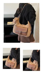 Detail of large capacity brown suede shoulder bag featuring a cute plush bear charm