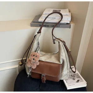 Large capacity textured faux leather hobo bag with brown front pocket and plush dog charm
