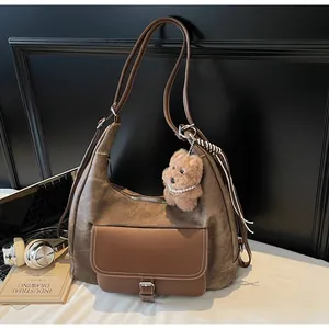 Large brown vintage tote bag with bear charm and commuter lifestyle accessories