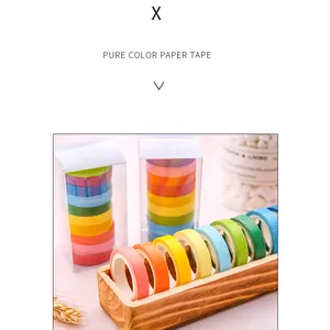 Vue détaillée de rouleaux de ruban washi coloré rangés dans un support en bois naturel.