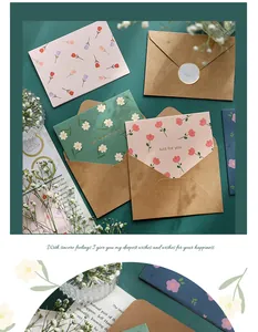 Primer plano de tarjetas de felicitación floral con sobres de kraft y mensajes.