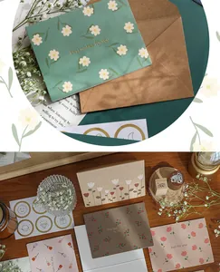 Detalle de tarjetas de felicitación florales con elegantes letras doradas y sobres.