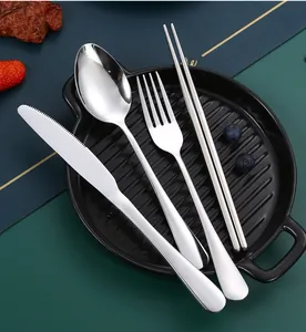 Close-up of stainless steel cutlery set including knife, fork, spoon, and chopsticks.