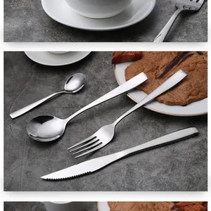Close-up of modern 4-piece stainless steel cutlery set on a rustic slate background.