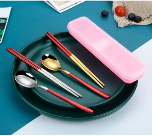 Close-up of red and gold portable stainless steel spoon and chopsticks set with case