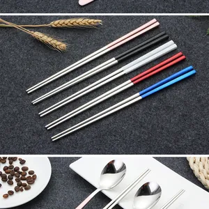 Detail view of 304 stainless steel chopsticks with multi-colored handles on grey felt.