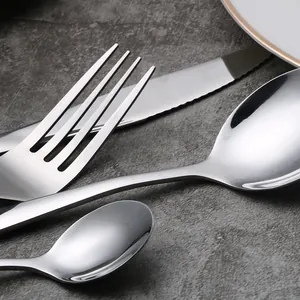 Close-up view of a four-piece stainless steel cutlery set including fork, knife and spoons