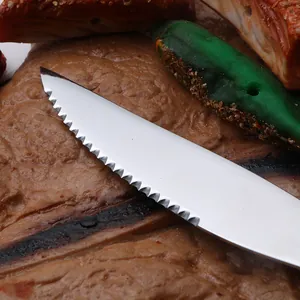 Macro view of a sharp serrated dinner knife made of 410 stainless steel on a rustic food background