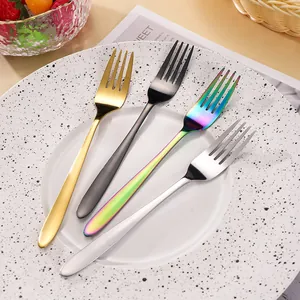 Modern stainless steel fork set of 4 in gold black rainbow and silver on a plate