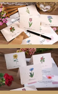 Detalle de tarjetas de felicitación botánicas vintage con ilustraciones de flores y sobres kraft.
