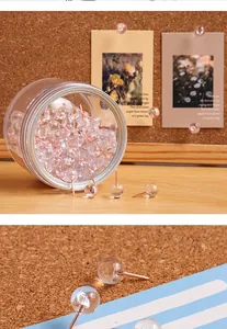 Detaillierte Makroansicht von 100 transparenten Reißzwecken mit roségoldenen Nadeln.