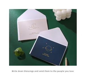 Close-up of gold-stamped greeting cards with minimalist moon and planet designs.