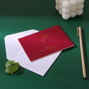 Elegant red greeting card featuring gold foil rose design with matching white envelope