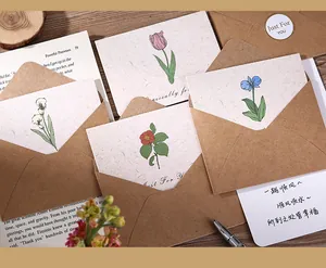 Vista detallada de tarjetas de felicitación florales vintage con sobres de papel kraft y sellos.