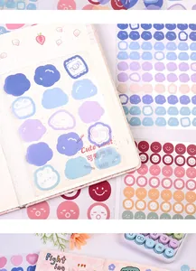 Close-up van kleurrijke pastelwolk- en stipstickers op een dot grid dagboek.