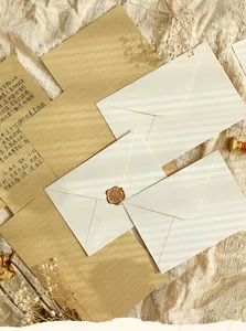 Vue détaillée d'enveloppes vintage à texture de lin sur un tissu beige doux