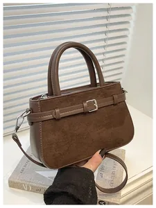 Close-up detail of vintage brown handbag featuring elegant suede and leather texture