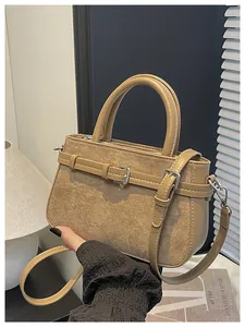Close-up of elegant beige handbag featuring suede texture and belt buckle detail work