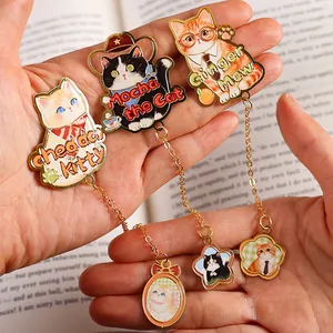 Set of three cute cartoon cat metal bookmarks with dangling charms and enamel details