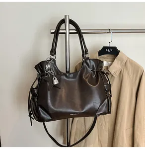 Detailansicht einer dunkelbraunen Vintage-Einkaufstasche aus Kunstleder an einem Ständer