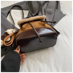 Detailansicht eines braunen Vintage-Eimer-Rucksacks mit Kunstpelzbesatz und Bärenanhänger.