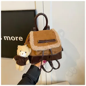Nahaufnahme eines braunen Vintage-Wildlederrucksacks mit Fellbesatz und Teddybär-Anhänger