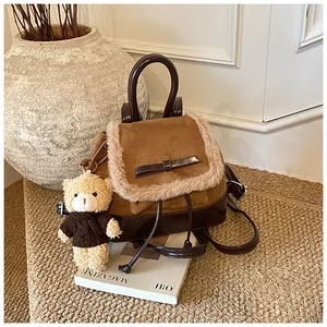 Nahaufnahme eines braunen Vintage-Rucksacks mit Pelzbesatz und Teddybär-Anhänger