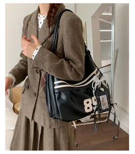 Primo piano di una borsa a tracolla nera capiente con stampa sportiva del numero 89