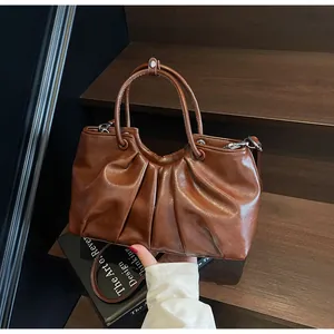 Dettaglio borsa a secchiello plissettata in morbida pelle marrone stile vintage