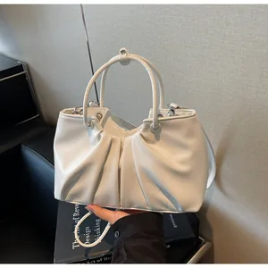 Dettaglio della morbida pelle bianca e del design a pieghe della borsa a secchiello