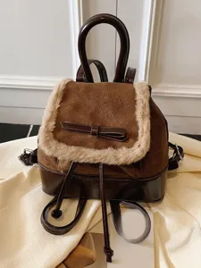 Klassischer brauner Damenrucksack mit Kunstfellbesatz und Schleife auf beigem Stoff