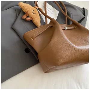 Dettaglio di borsa tote in pelle martellata marrone con fibbia in metallo argento fine