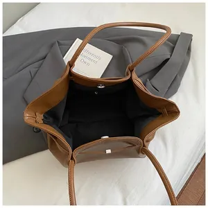 Vista interna dettagliata della borsa tote in pelle marrone con fodera nera e clip