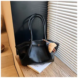 Elegante borsa tote in pelle martellata nera con un simpatico ciondolo a croissant