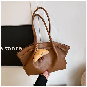 Elegante borsa tote in pelle martellata marrone con un simpatico ciondolo a forma di croissant