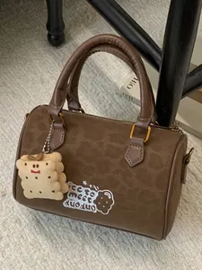 Vintage brown suede handbag featuring cute cookie embroidery and a matching plush charm