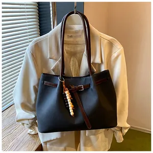 Λεπτομερής άποψη vintage μαύρης τσάντας tote σε συνδυασμό με ένα κομψό σακάκι