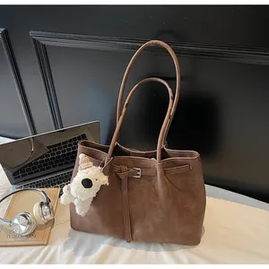 Bolso tote grande marrón vintage con charm de perro en un entorno de oficina profesional