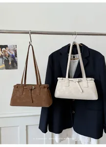 Detailansicht eleganter Retro-Tragetaschen in Braun und Creme mit einem Blazer gestylt