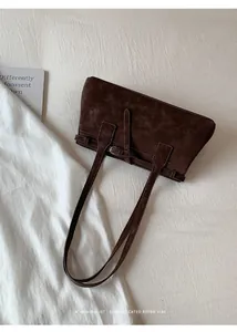 Detailansicht einer braunen Wildleder-Tragetasche im minimalistischen Retro-Stil