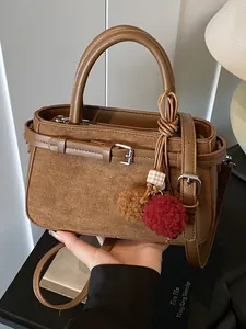 Stylish retro brown suede handbag with buckle strap and pompom charm for women
