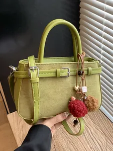 Vintage green matte leather handbag featuring adjustable strap and plush ball charms