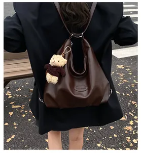 Vista posteriore di una grande borsa tote vintage marrone indossata come zaino
