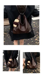 Vista dettagliata della borsa tote vintage marrone scuro con ciondolo a orso