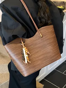 Elegant brown woven large capacity tote bag for women featuring a bead tassel charm
