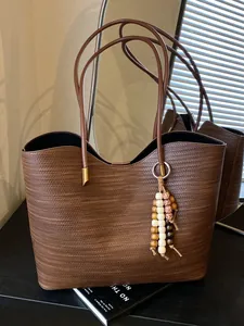 Large capacity brown tote bag with woven texture and beaded charm for commuter style.