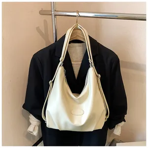 Grande borsa tote retrò color crema esposta su un blazer nero per look da ufficio