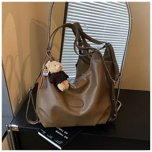 Vista dettagliata della borsa tote vintage marrone con ciondolo a forma di orsetto