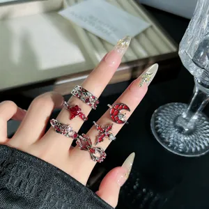 Detailansicht von Gothic-Punk-Ringen mit roten Spinnennetz- und Kreuzmotiven