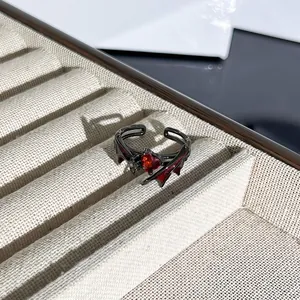 Primer plano de anillo gótico de Halloween con gema de corazón rojo y alas de murciélago